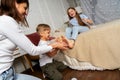 Mom in the bedroom on the bed fun tickles the legs of children, boys and girls.