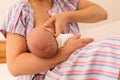 The mom is breastfeeding her newborn baby on the bed Royalty Free Stock Photo