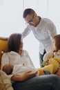 Mom breastfeeding her newborn son with her father and daughter. family of four