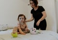 Mom brushes her baby daughter with a cast on her leg. Royalty Free Stock Photo