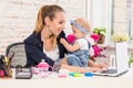 Mom and businesswoman working with laptop computer at home and playing with her baby girl. Royalty Free Stock Photo