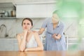 Mom calms down her adult daughter after a domestic quarrel in kitchen