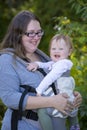 Mom carrying baby girl with carrier, enjoying the day in the park