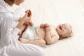 Mom changing diaper to the baby lying on his back Royalty Free Stock Photo