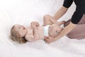 Mom changing diaper to the baby lying on his back Royalty Free Stock Photo