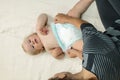 Mom changing diaper to the baby lying on his back Royalty Free Stock Photo