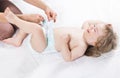 Mom changing diaper to the baby lying on his back Royalty Free Stock Photo