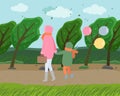 Mom and child with balls walking in autumn park, cold windy weather, trees are sloping from wind