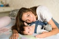 Mom with a child in bed. Happy loving family. Mother and her daughter child girl playing together Royalty Free Stock Photo