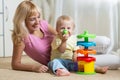 Mom and her child with colorful logical toy. Family having a fun playing together at home. Royalty Free Stock Photo