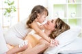 Mom and child daughter embracing and kissing in