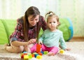 Mom and child daughter play block toys home