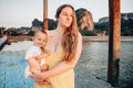 Mom with a child looks thoughtfully at the sea. They stand on the pantone pier early in the morning. Very happy baby Royalty Free Stock Photo