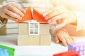 Mom and child together build a house of cubes and blocks constructor. Close up of hands holding roof. Playing parents and children Royalty Free Stock Photo