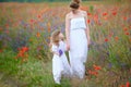 Mom and child walking holding hands outdoors. Two women in dress Royalty Free Stock Photo