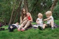 Mom with children on picnic. Mother photographing children when they are playing