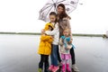 Mom with children stands under an umbrella in rainy weather. Royalty Free Stock Photo