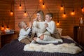 Mom with children in the winter frosty evening lying on the bed together. Royalty Free Stock Photo