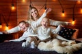 Mom with children in the winter frosty evening lying on the bed together. Royalty Free Stock Photo