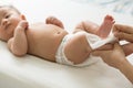 Mom cleaning up and wipe body baby by wet tissue when changing nappies or diaper and wiping the hands or face or leg,