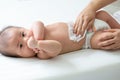 Mom cleaning up and wipe body baby by wet tissue when changing nappies or diaper and wiping the hands or face or leg