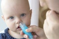 Mom cleans baby`s nose using a nasal aspirator Royalty Free Stock Photo