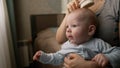 A mother combs her little boy's hair. A cute boy is sitting on his mother's lap. Mother with Baby. Mom combs the Royalty Free Stock Photo