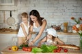 Mom cooks lunch with the kids. A woman teaches her daughter to cook from her son. Vegetarianism and healthy natural food. Royalty Free Stock Photo