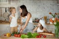 Mom cooks lunch with the kids. A woman teaches her daughter to cook from her son. Vegetarianism and healthy natural food Royalty Free Stock Photo