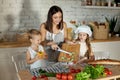 Mom cooks lunch with the kids. A woman teaches her daughter to cook from her son. Vegetarianism and healthy natural food. Royalty Free Stock Photo