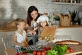 Mom cooks lunch with the kids. A woman teaches her daughter to cook from her son. Vegetarianism and healthy natural food Royalty Free Stock Photo