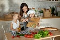 Mom cooks lunch with the kids. A woman teaches her daughter to cook from her son. Vegetarianism and healthy natural food Royalty Free Stock Photo