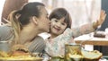 Mom with a cute daughter eating fast food in a cafe