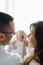 Mom and dad from behind holding their newborn son yawning. New parents Royalty Free Stock Photo