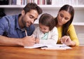 Mom, dad and child at table with homework for teaching, learning and support in education with love. Writing, drawing Royalty Free Stock Photo