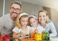 Mom, dad and children in the kitchen, cooking together and learning. Portrait of family at home teaching kids how to