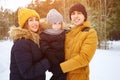 Mom and dad are cuddling and kissing their little son in winter park. Royalty Free Stock Photo