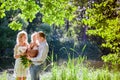 Mom , dad and daughter on the background of the forest and water