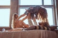 Mom, dad and daughter in bed. Father playing with adorable daughter in bedroom.