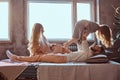 Mom, dad and daughter in bed. Father playing with adorable daughter in bedroom.