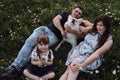 Young Caucasian European happy family with half breed white Swiss Shepherd is enjoying life. Mom dad daughter and big fluffy white Royalty Free Stock Photo