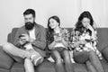 Mom dad and daughter relaxing on couch. Family spend weekend online. Child little girl use smartphone with parents Royalty Free Stock Photo