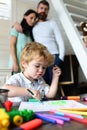 Mom and dad drawing with child. Happy family of three having fun together. Cheerful parents playing with son. Father Royalty Free Stock Photo