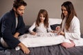 Mom, dad and girl with playing cards fun in home with bonding, learning and relax with strategy in bedroom. Father Royalty Free Stock Photo