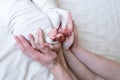 Mom and dad hands hold small legs of their two newborn twin babies Royalty Free Stock Photo