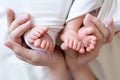 Mom and dad hands hold small legs of their two newborn twin babies Royalty Free Stock Photo