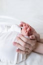 Mom and dad hands hold small legs of their two newborn twin babies Royalty Free Stock Photo