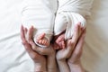 Mom and dad hands hold small legs of their two newborn twin babies Royalty Free Stock Photo