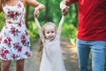 Mom and dad hold their daughter hands. Happy successful family. Royalty Free Stock Photo