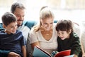 Mom, dad and kids reading books on sofa for storytelling time with smile in happy family home. Love, learning and couple